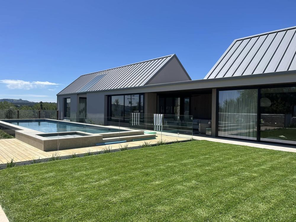 Two-storey home finished in exterior render, showing an even drag-finish texture across the elevation